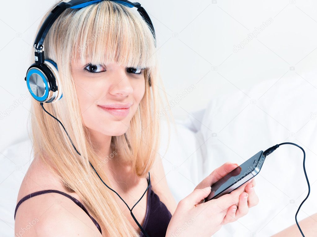 Pretty blond girl listening to music on her smartphone