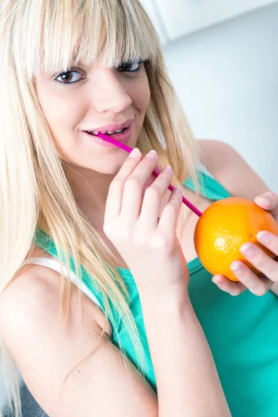 Meisje een oranje drinken uit een rietje — Stockfoto