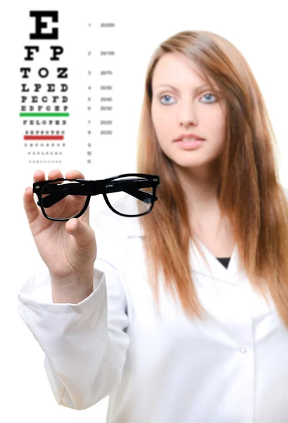 Optician giving a patient glasses to try on — Stock Photo, Image