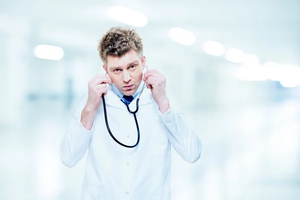 Médico bonito ouvindo com um estetoscópio — Fotografia de Stock