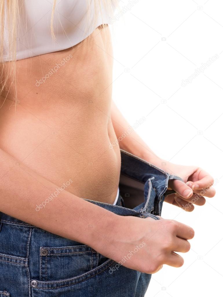 Slim female pulling oversized jeans