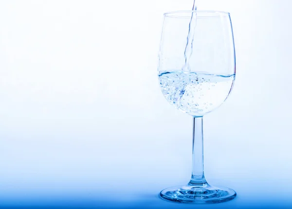 Vatten hälls upp från en flaska i ett glas — Stockfoto