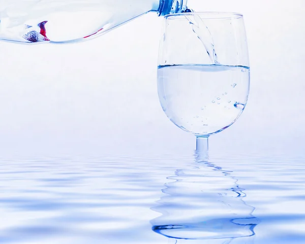 Drinking water wordt uit een fles gegoten in een glas — Stockfoto