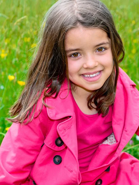 Heureux mignon enfant assis dans une herbe d'un jardin de fleurs — Photo