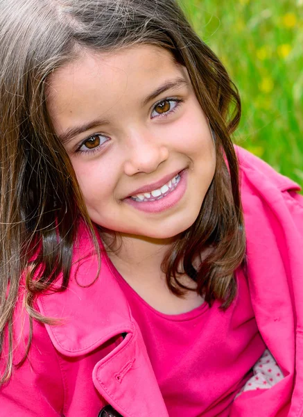 Heureux mignon enfant assis dans une herbe d'un jardin de fleurs — Photo