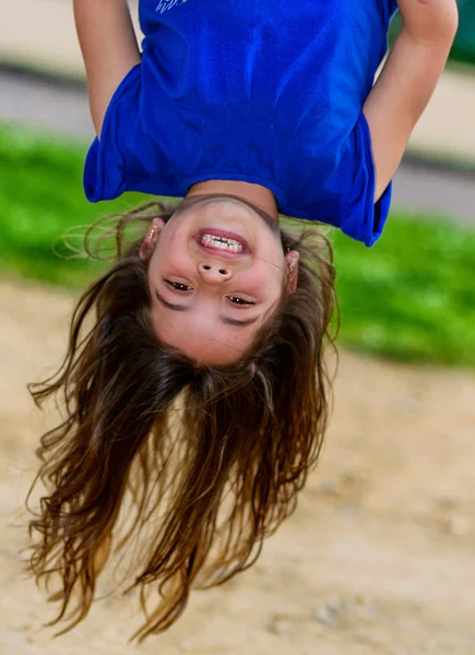 Beautiful child hanging upside and laughing — Stock Photo, Image