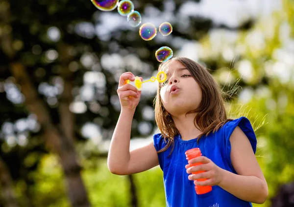 Bela criança soprando bolhas — Fotografia de Stock