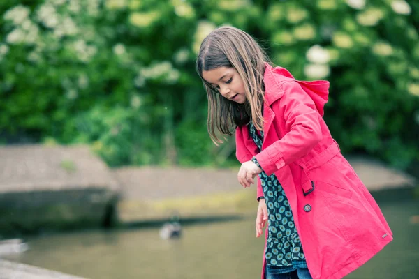 Vrij klein meisje spelen op de rand van het water — Stockfoto