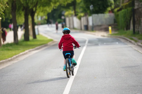 Young child doing the bike alone in the middle of the road — Stock Photo, Image