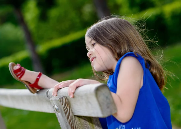 Schönes Porträt des niedlichen Kindes, das mit Grün im Hintergrund spielt — Stockfoto