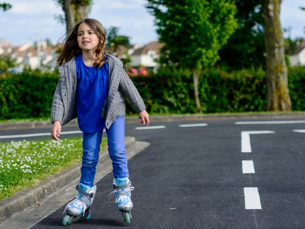 Söt liten tjej gör rollerblade på gatan — Stockfoto