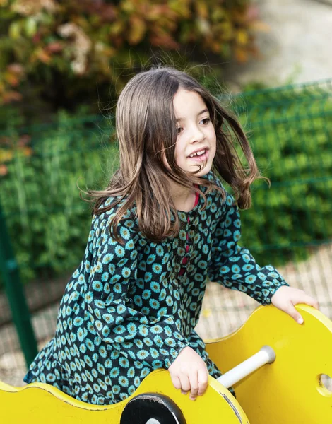 Schönes Porträt eines hübschen Mädchens auf einem Kinderkarussell — Stockfoto