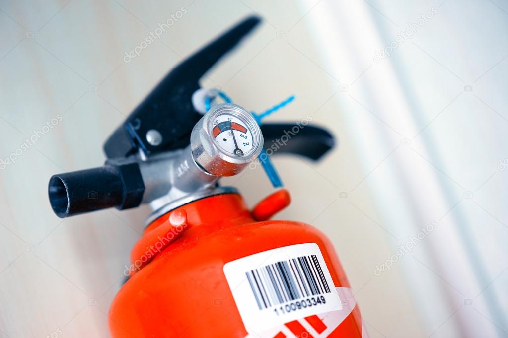 Red fire extinguisher fixed on an interior wall