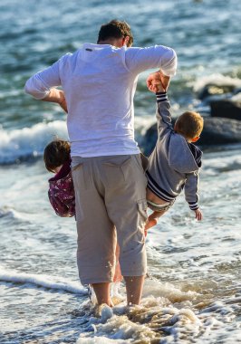 iki çocuk ve okyanus önünde oynarken onların baba