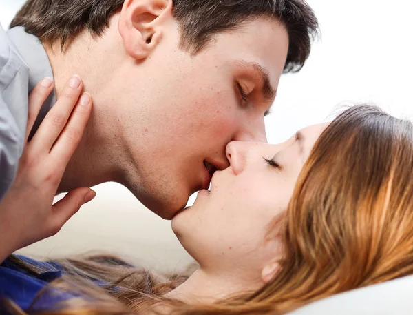 Kendisini sevgiyle kanepede öpüşme aşık çekici çift — Stok fotoğraf