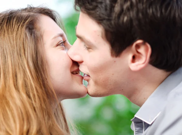 Attractive couple of lovers kissing itself lovingly on a sofa — Stock Photo, Image