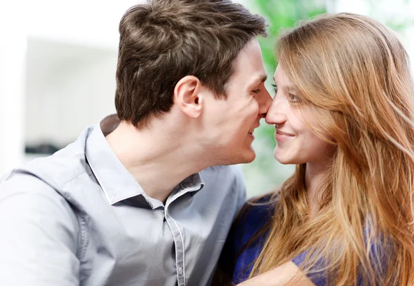 Muito atraente jovem casal flertando em um sofá — Fotografia de Stock