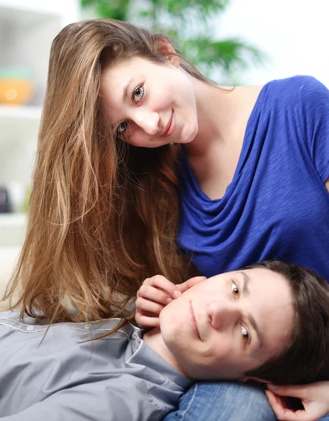 Schattig man verlengd op de dijen van zijn vriendin op een sofa — Stockfoto