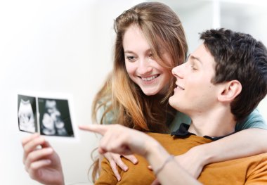 Bebeklerinin ultrason fotoğraflarıyla seyreden güzel bir çift.