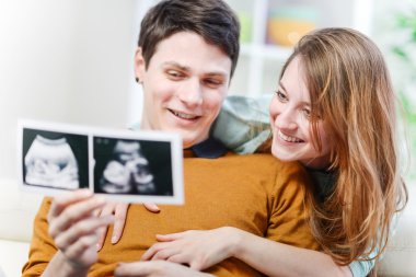 Bebeklerinin ultrason fotoğraflarıyla seyreden güzel bir çift.