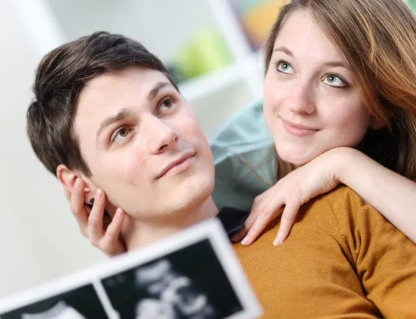 Şirin çift doğmamış çocuklarının ellerde ultrason resimleri ile geleceği hayal etmez. — Stok fotoğraf