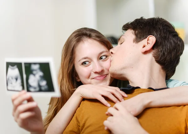 Bebeklerinin ultrason fotoğraflarıyla seyreden güzel bir çift. — Stok fotoğraf