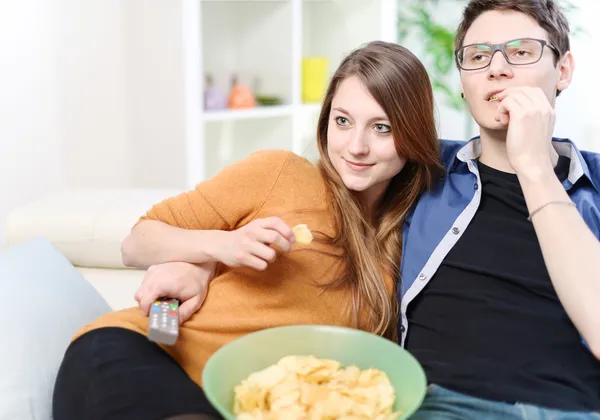 Hübsche Verliebte vor dem Fernseher auf dem Sofa in der Studiowohnung — Stockfoto