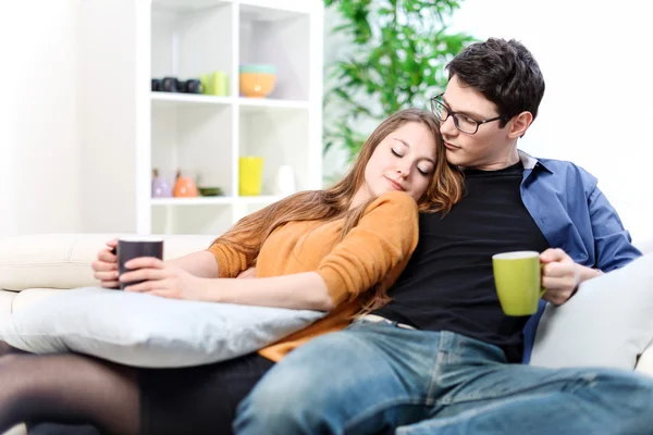 Casal alegre relaxando juntos no sofá na sala de estar — Fotografia de Stock