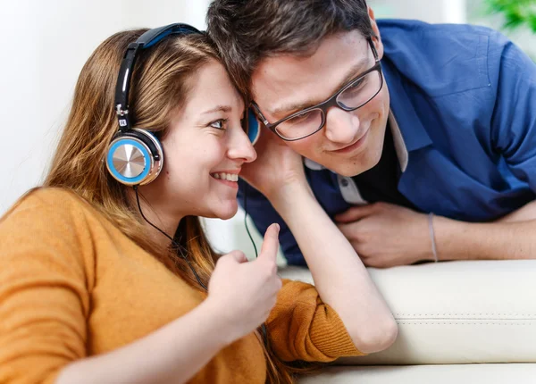 Atractiva pareja joven escuchando música juntos en su vida —  Fotos de Stock