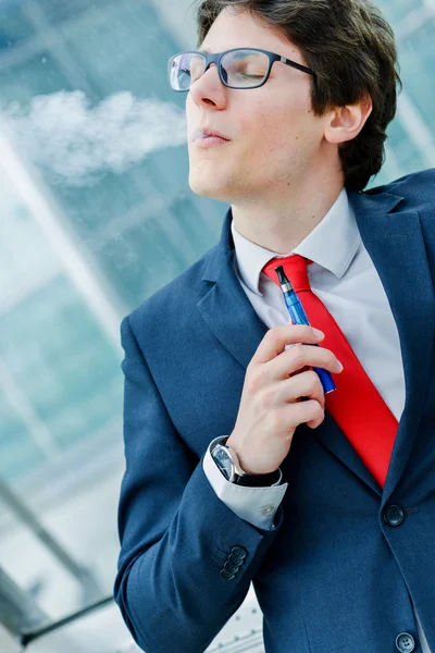 Lindo hombre adulto joven inhalando de un cigarrillo electrónico —  Fotos de Stock