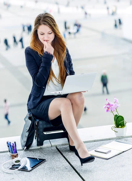 Stressed junior executive dynamic working outside of her office — Stock Photo, Image