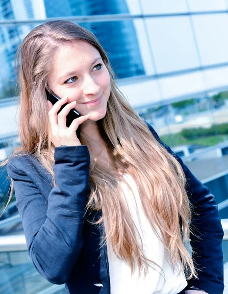 Junior uitvoerend dynamische bellen buiten haar office — Stockfoto