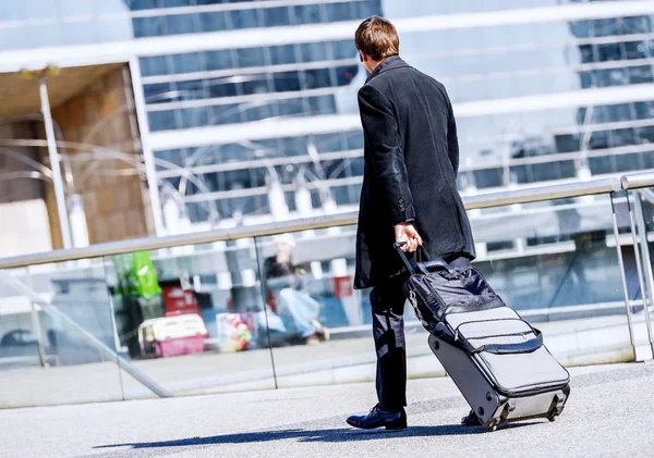 Homme d'affaires marchant avec une valise dans la rue — Photo