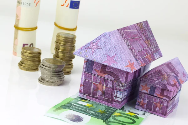 Concepto inmobiliario con billetes de banco en euros Casa y monedas — Foto de Stock