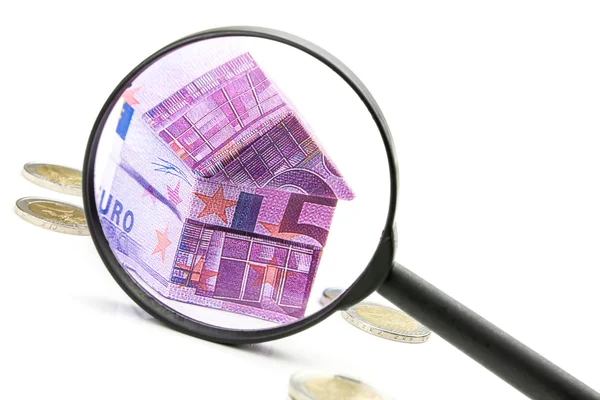 Euro bill huis en uitgaven onder Vergrootglas — Stockfoto