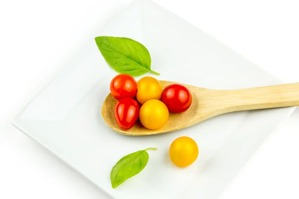 Colorful cherry tomatos on wooden spoon — Stock Photo, Image