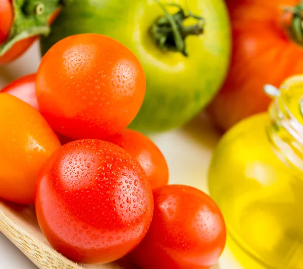 Varieties of colorful tomatos and olive oil — Stock Photo, Image