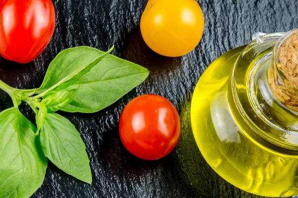 Разновидности разноцветных помидоров и оливкового масла — стоковое фото