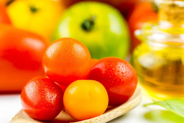 Varieties of colorful tomatos and olive oil — Stock Photo, Image