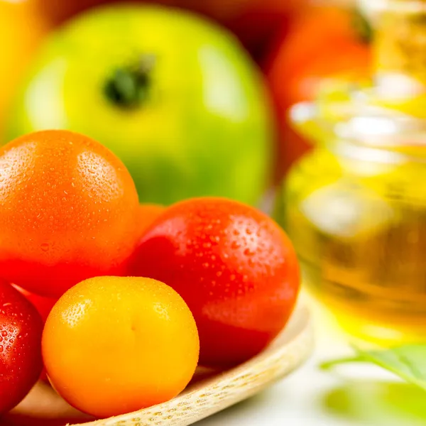 Varieties of colorful tomatos and olive oil — Stock Photo, Image