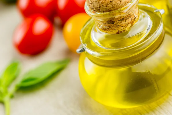 Bottle of olive oil with cherry tomatoes — Stock Photo, Image