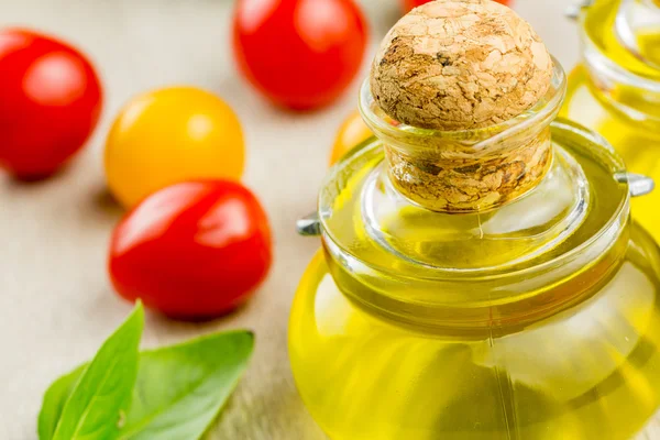 Bottle of olive oil with cherry tomatoes — Stock Photo, Image