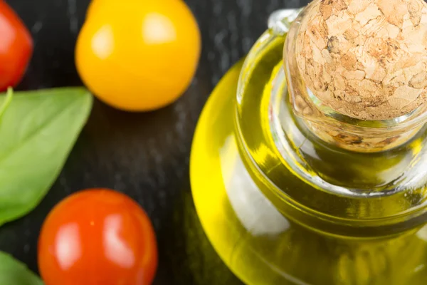 Bottle of olive oil with cherry tomatoes — Stock Photo, Image