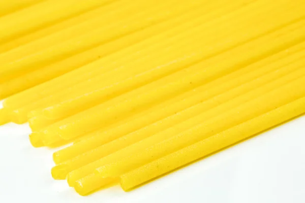 Spaghetti italiani crudi su fondo bianco — Foto Stock