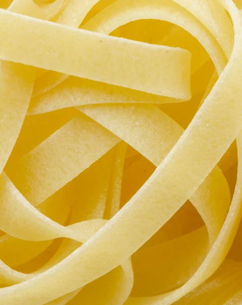 Uncooked Italian tagliatelle on a white background — Stock Photo, Image