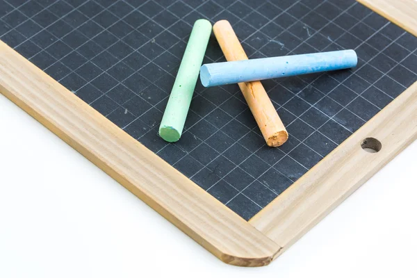 Colored chalk placed on a school slate — Stock Photo, Image