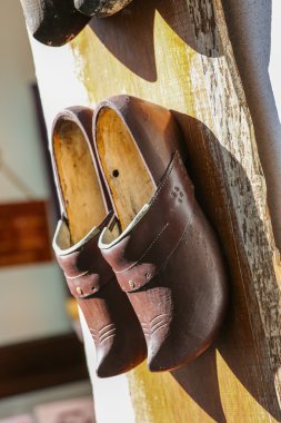 tradycyjne drewniane buty wiszące na ścianie
