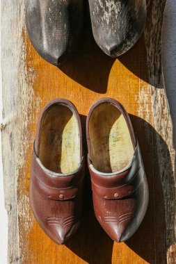 tradycyjne drewniane buty wiszące na ścianie