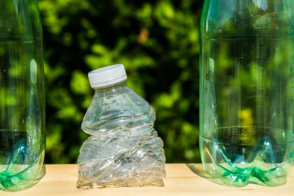 Tres botellas de plástico con una botella triturada — Foto de Stock