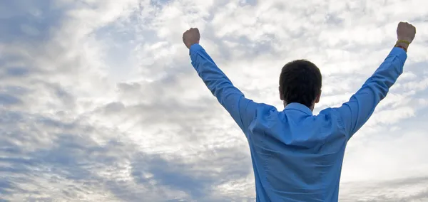 Man die zich uitstrekt van zijn armen omhoog in de lucht — Stockfoto